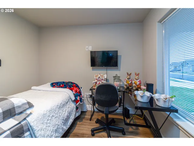 a bedroom with a bed a chair and a potted plant