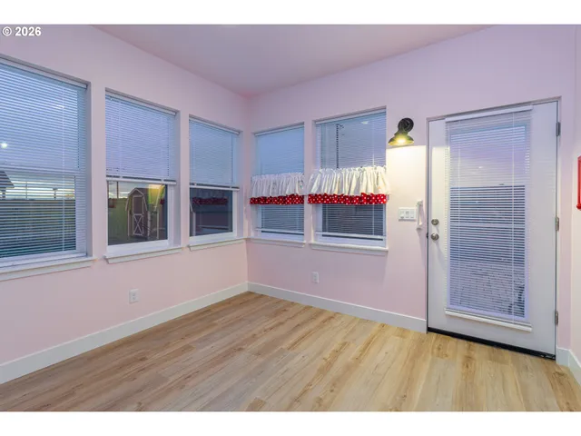 a view of an empty room with window and cabinet
