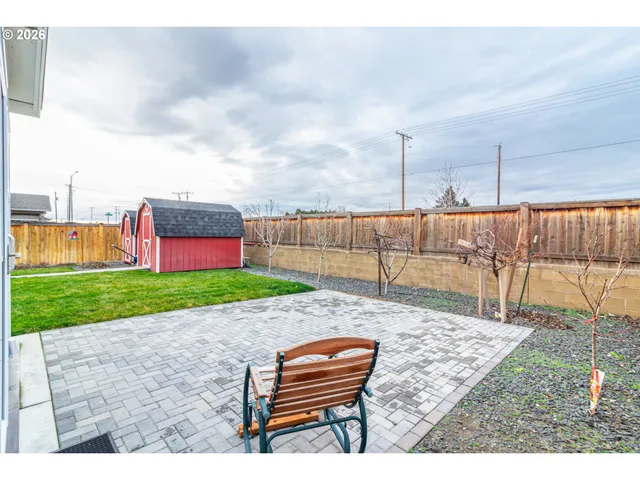 a backyard of a house with a garden and barbeque oven