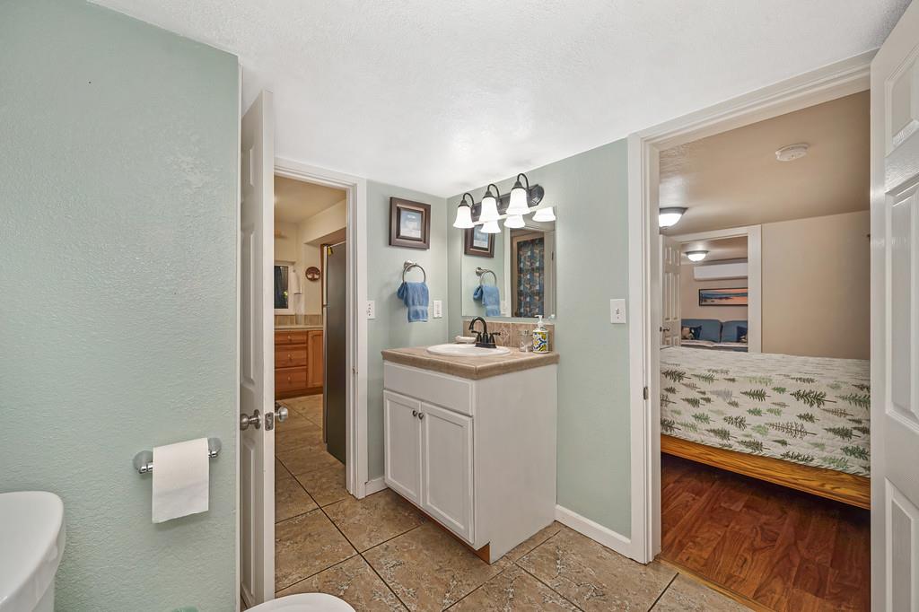 6252 Pony Express Trail Pollock Pines, CA 95726 - Photo 24 of 43 a bathroom with a sink a mirror and a toilet