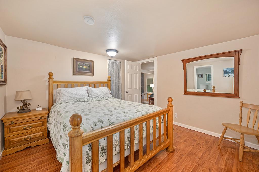 6252 Pony Express Trail Pollock Pines, CA 95726 - Photo 25 of 43 a bed sitting in a bedroom next to a wooden floor