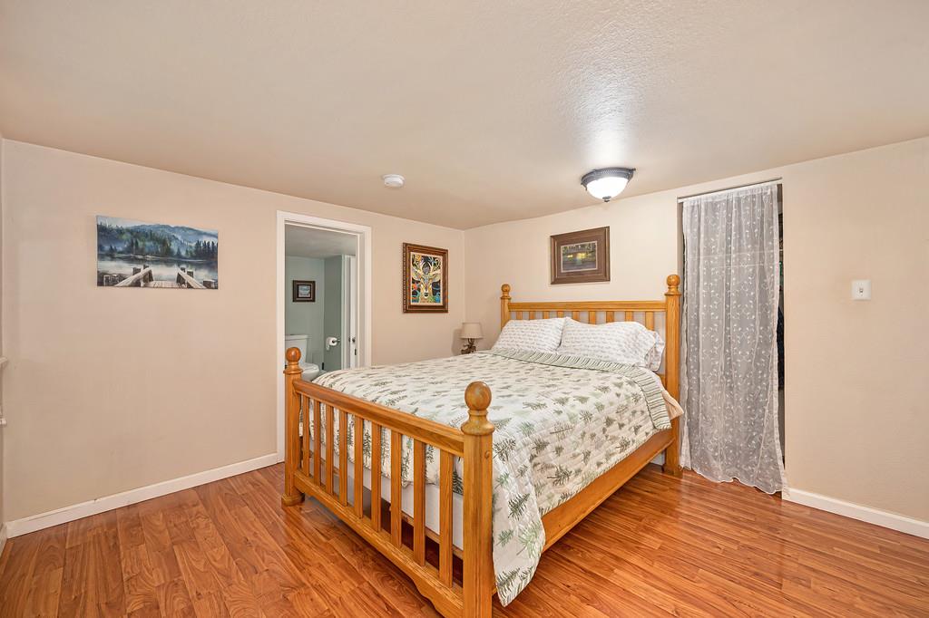 6252 Pony Express Trail Pollock Pines, CA 95726 - Photo 26 of 43 a bedroom with a bed and wooden floor