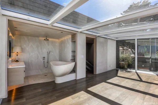 a bathroom with a tub sink and mirror