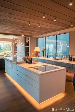 a living room with furniture large windows and a fireplace