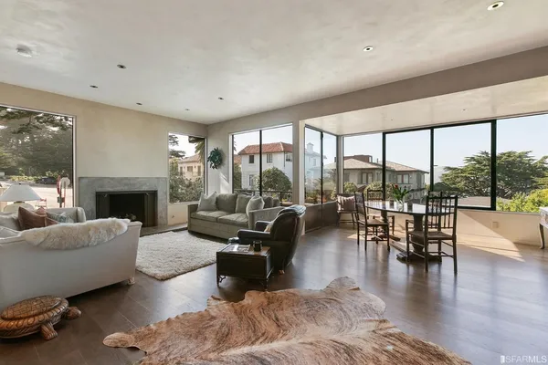 a living room with furniture a large window and a fireplace