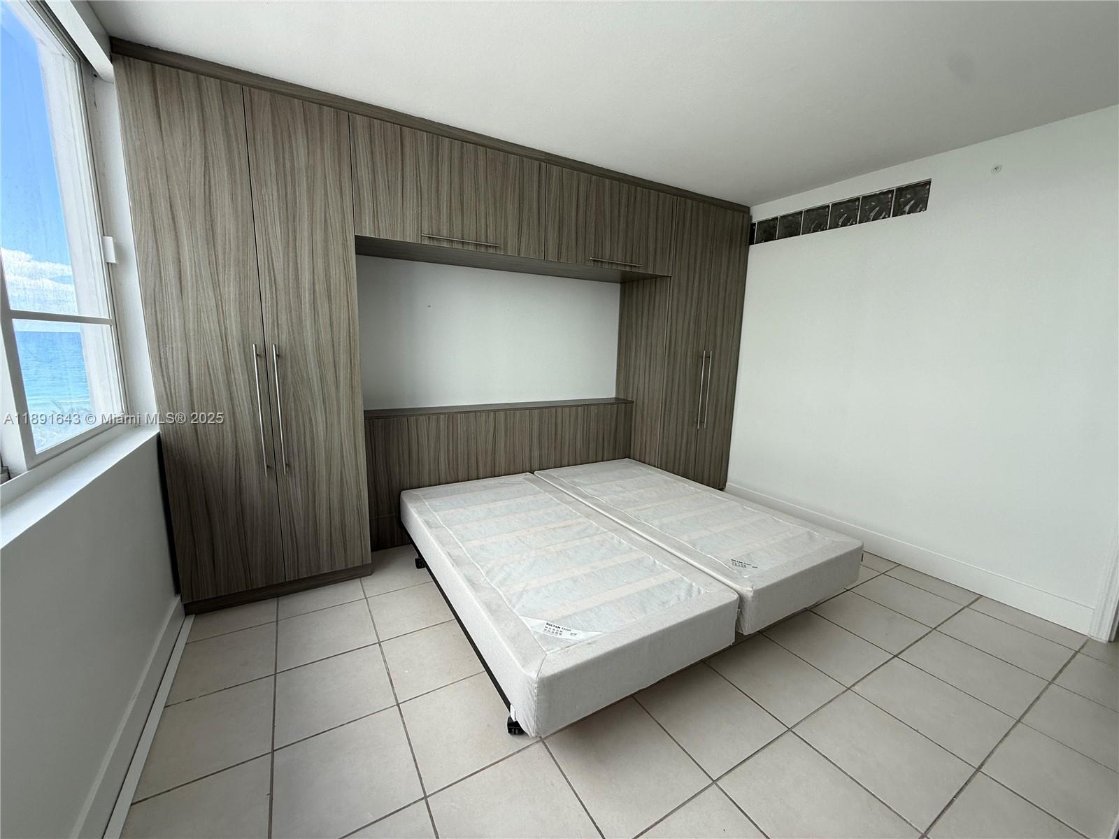 5005 Collins Avenue, Unit 823 Miami Beach, FL 33140 - Photo 26 of 34 a bedroom with a bed and a window