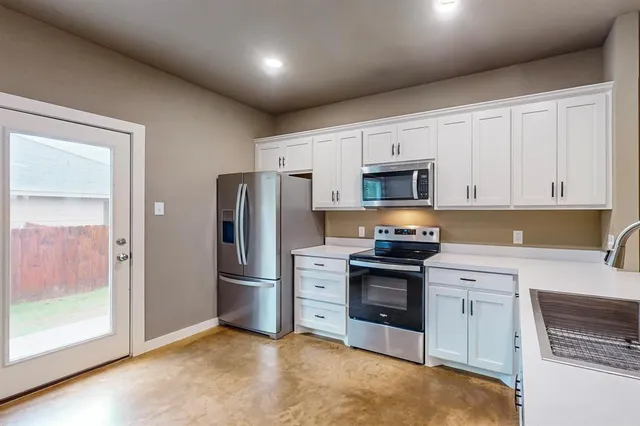 a kitchen with stainless steel appliances granite countertop a refrigerator stove and sink