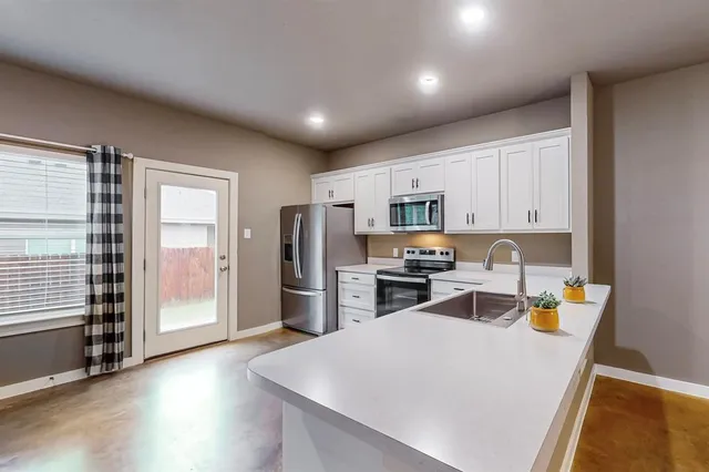 a kitchen with stainless steel appliances a refrigerator sink and microwave