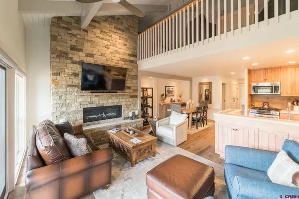 a living room with furniture wooden floor and a flat screen tv