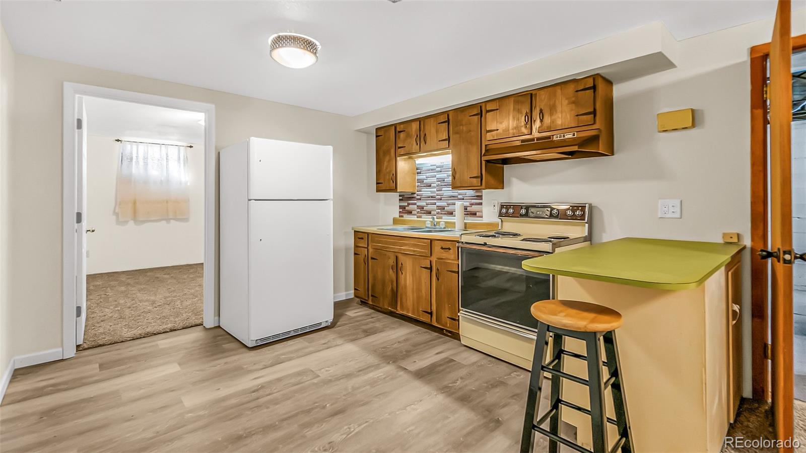 251 West 5th Street Akron, CO 80720 - Photo 16 of 30 a kitchen with a table chairs refrigerator and cabinets
