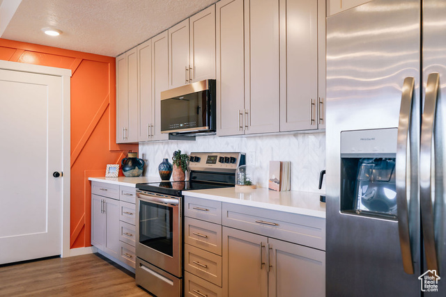 961 West Akoya Pearl Road, Unit 201 St. George, UT 84790 - Photo 7 of 67 Kitchen featuring appliances with stainless steel finishes, light countertops, gray cabinetry, a textured ceiling, and light wood finished floors