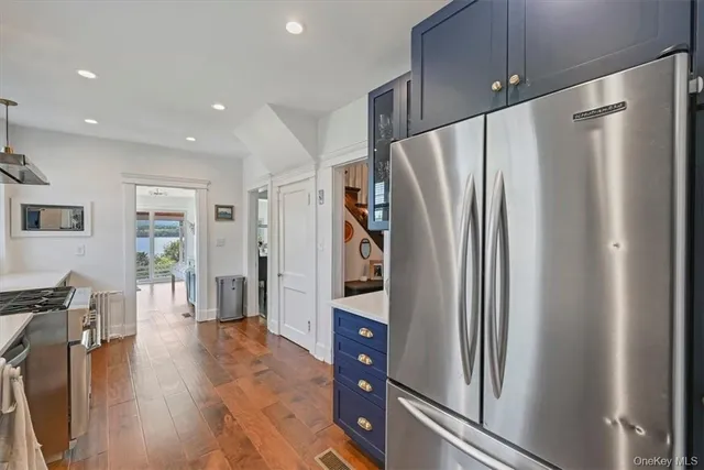 a kitchen with stainless steel appliances a refrigerator and wooden floor
