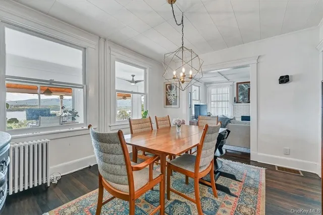 a view of a dining room with furniture a chandelier and wooden floor
