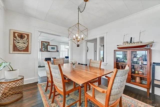 a dining room with furniture a chandelier and wooden floor