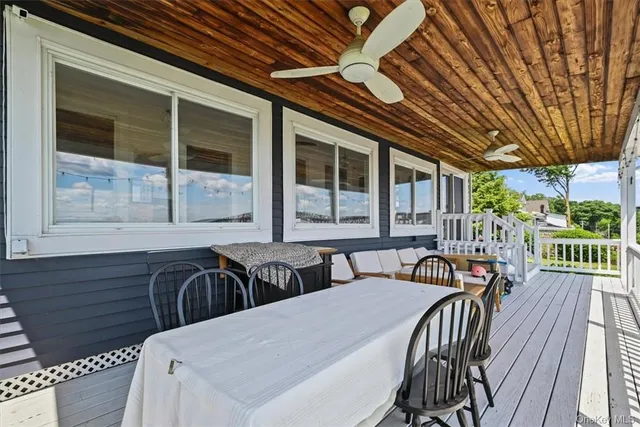 a view of a patio with table and chairs with wooden floor and fence