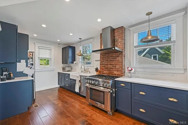a kitchen with a stove window and wooden cabinets