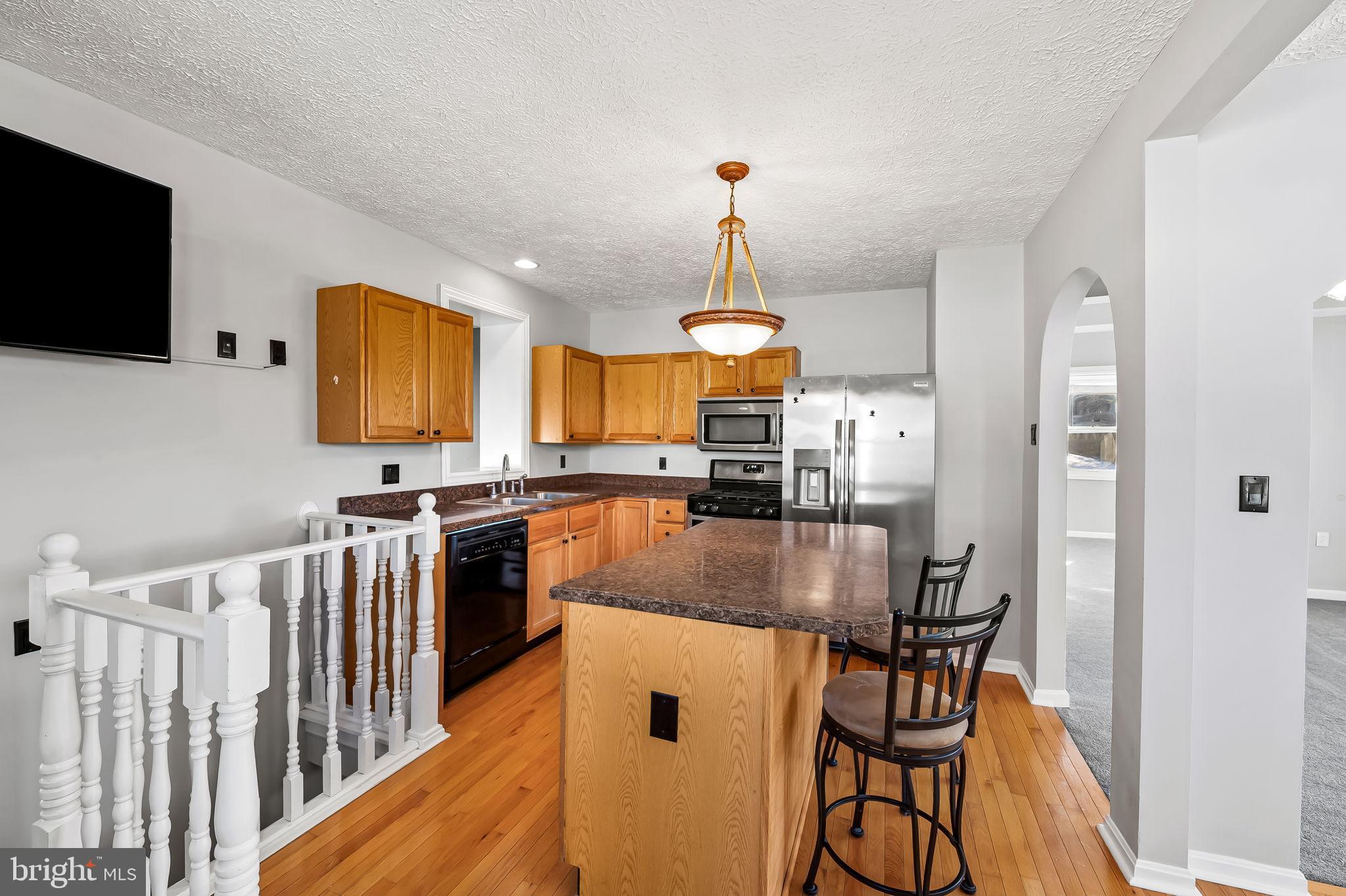 4222 Klosterman Avenue Nottingham, MD 21236 - Photo 11 of 43 a kitchen with stainless steel appliances a dining table chairs and a refrigerator