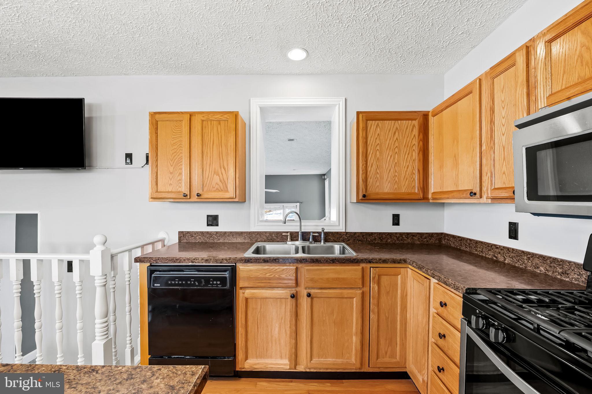 4222 Klosterman Avenue Nottingham, MD 21236 - Photo 14 of 43 a kitchen with stainless steel appliances granite countertop a sink stove and microwave