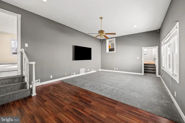 a kitchen with stainless steel appliances granite countertop a stove a refrigerator and a view of living room