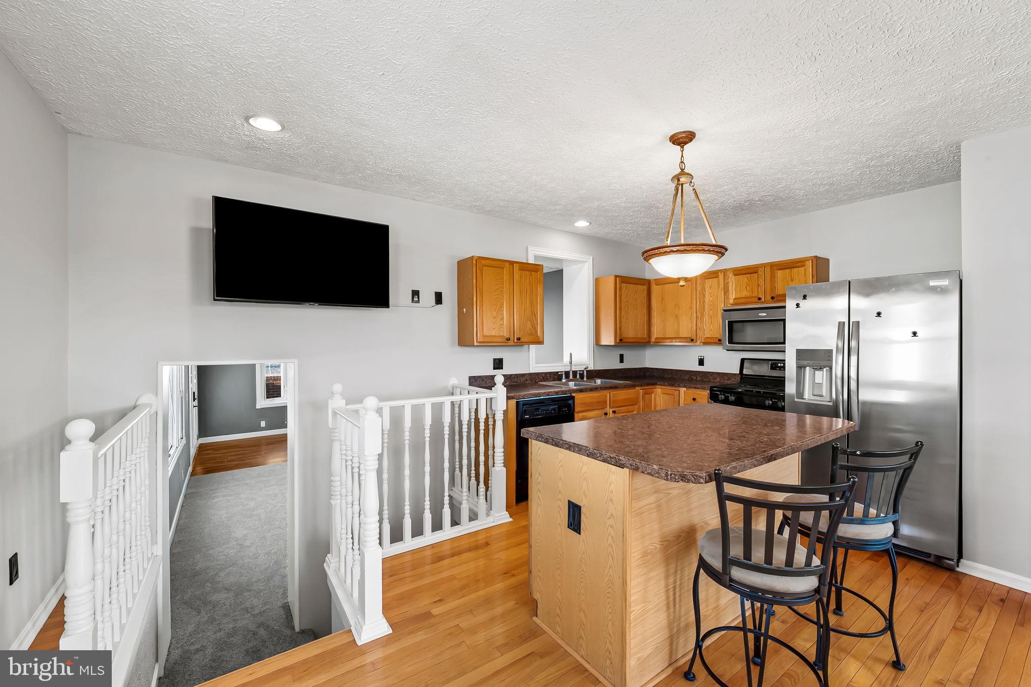 4222 Klosterman Avenue Nottingham, MD 21236 - Photo 10 of 43 a kitchen with stainless steel appliances granite countertop a stove top oven a sink a dining table and chairs