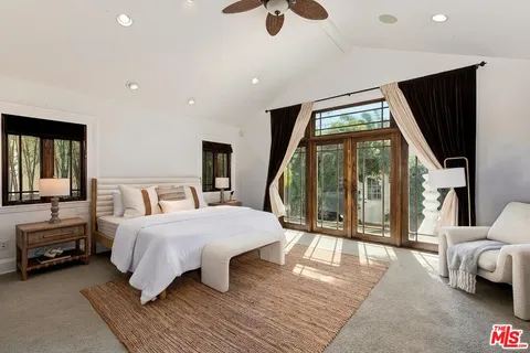 a bedroom with a large bed and a large window