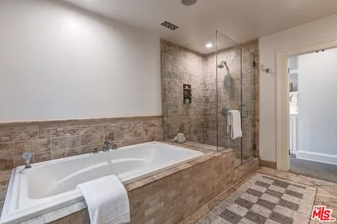 a spacious bathroom with a bathtub and a shower