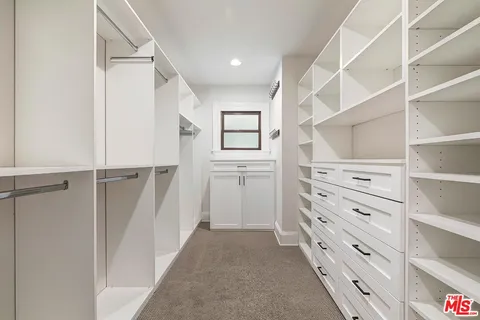 a view of walk in closet with empty racks