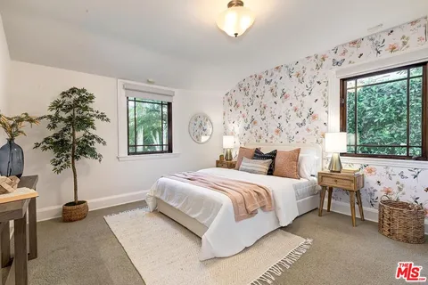 a bedroom with a large bed and a potted plant