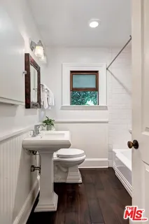 a bathroom with a sink toilet and a mirror