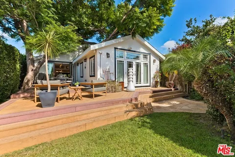 a view of a house with backyard sitting area and garden