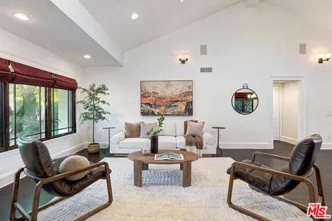 a living room with furniture and a floor to ceiling window