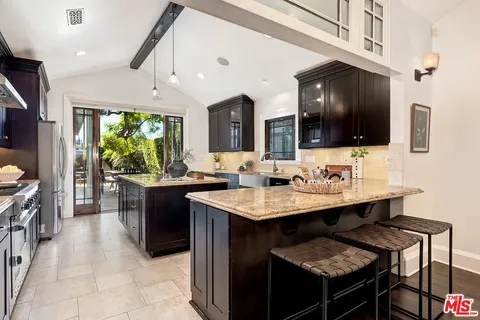a kitchen with a sink a counter top space appliances and cabinets