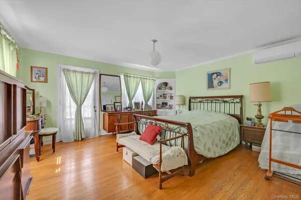 a bedroom with a bed and a flat tv screen on the dresser