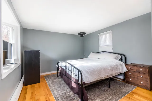 a bedroom with a bed and wooden floor
