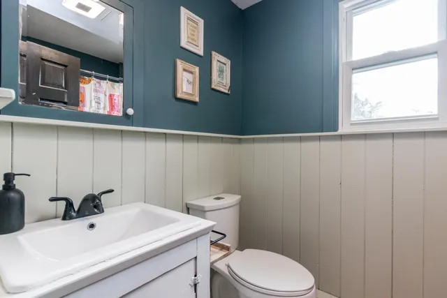 a bathroom with a toilet a sink and mirror