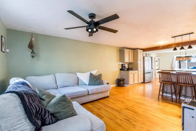 a living room with furniture and a view of kitchen