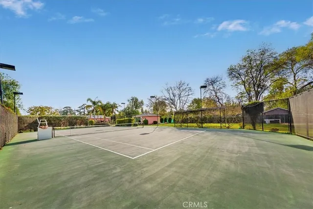 a view of swimming pool with outdoor seating and trees in the background