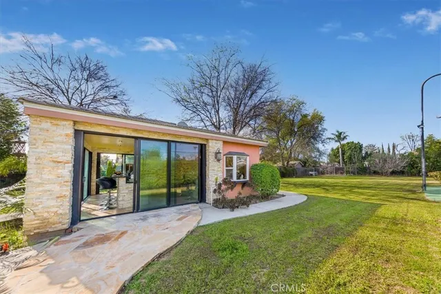 a room with kitchen island a large window in it and white appliances