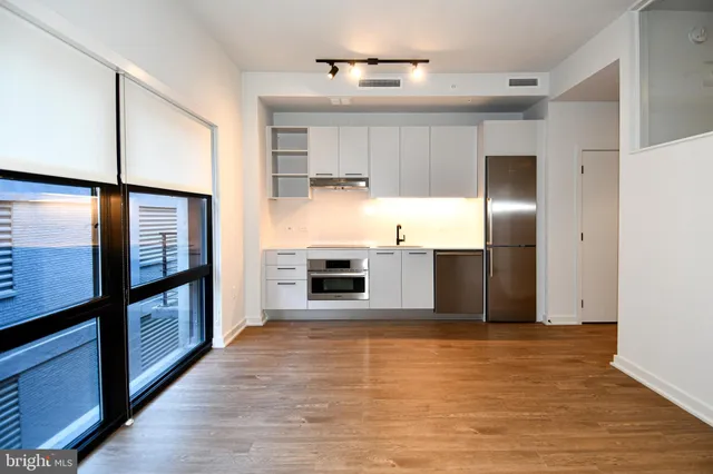 a kitchen with stainless steel appliances a refrigerator and a stove top oven