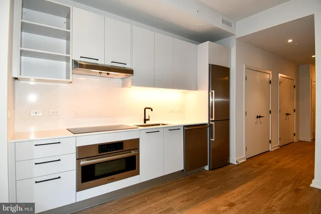 a kitchen with stainless steel appliances granite countertop a refrigerator and a stove