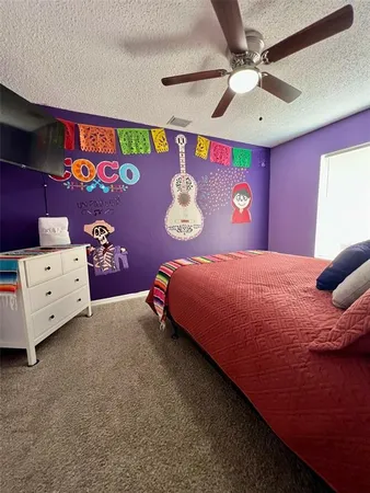 a bedroom with a bed and a lamp on dresser