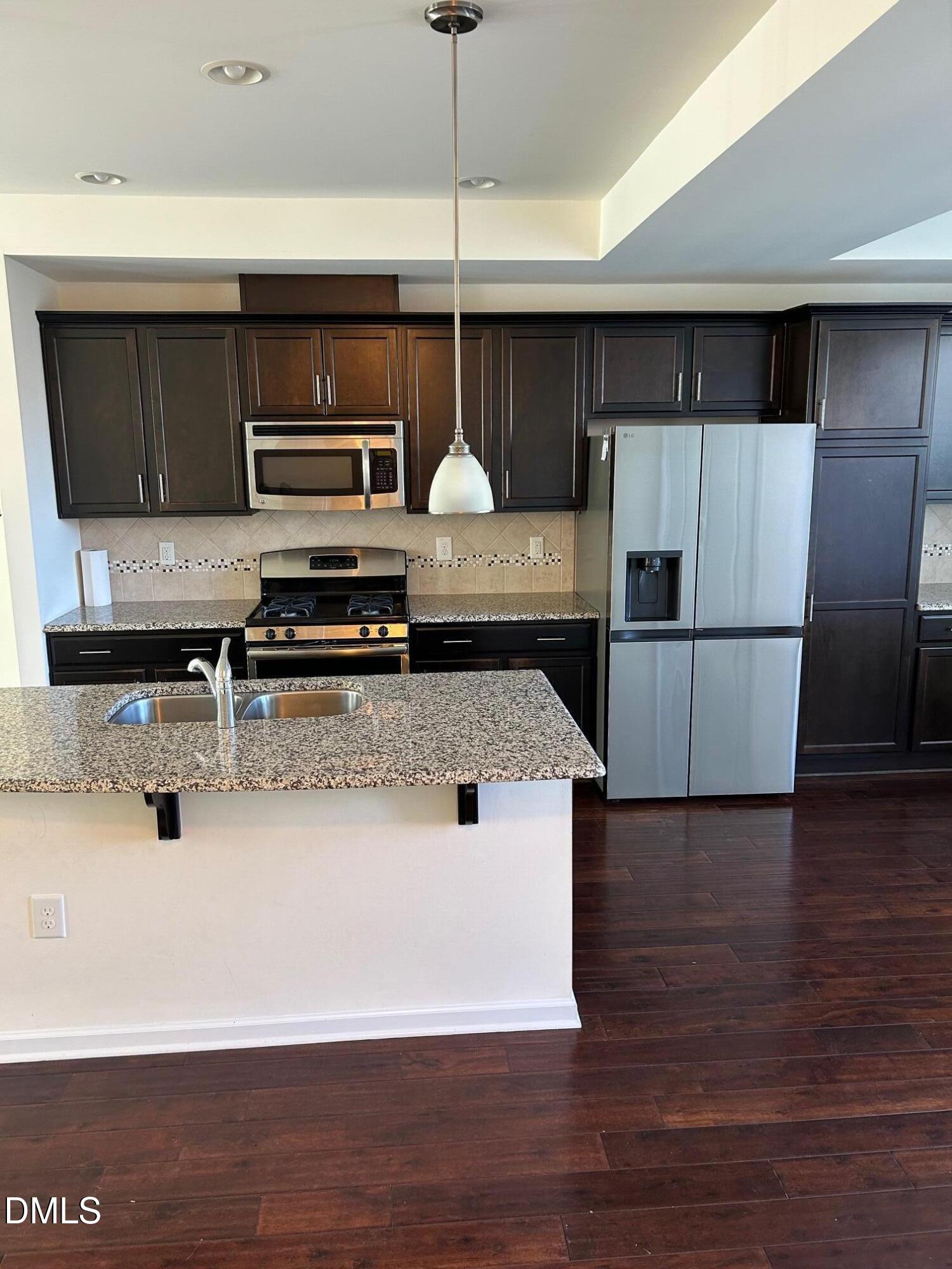 4110 Sykes Street Cary, NC 27519 - Photo 8 of 29 a kitchen with stainless steel appliances a microwave a stove and a refrigerator