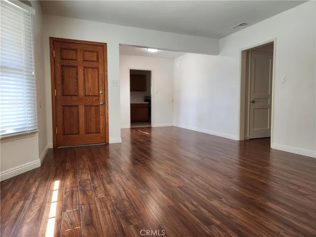 a view of empty room with wooden floor and windows