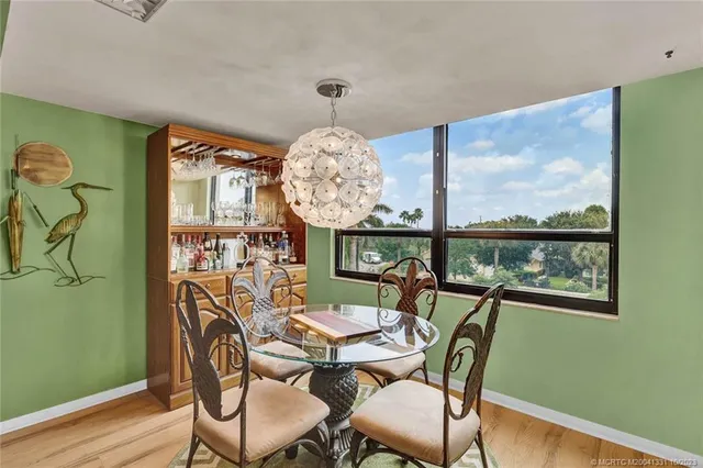 a view of a dining room with furniture a chandelier and wooden floor
