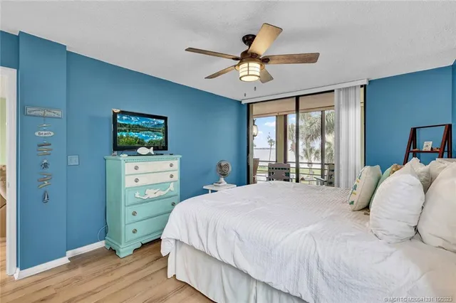 a bedroom with a bed and a flat tv screen on dresser