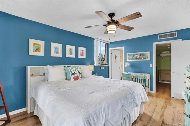 a bedroom with a large bed and a ceiling fan