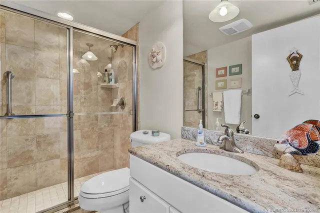 a bathroom with a granite countertop sink toilet and shower