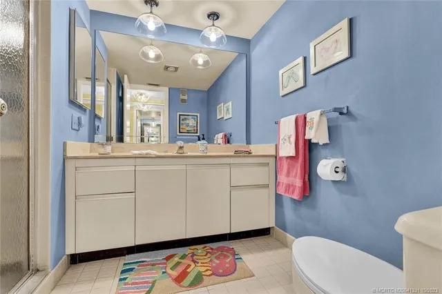 a bathroom with a sink vanity mirror and toilet