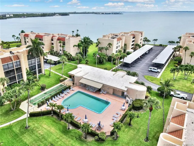 an aerial view of a house with a garden and lake view