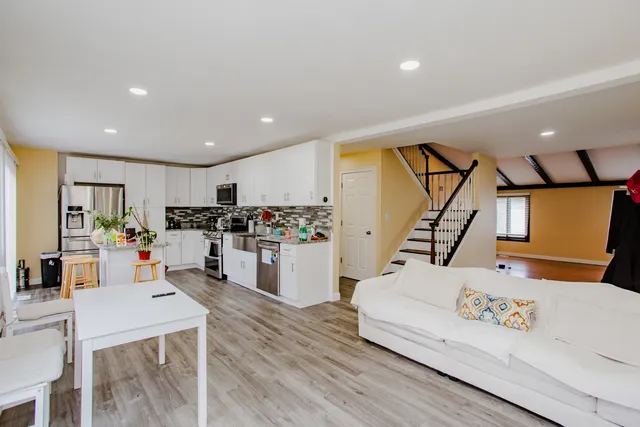 a living room with furniture and kitchen view